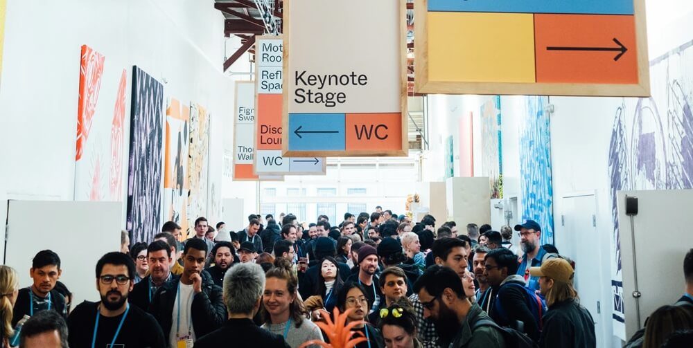 A crowd of people attending a trade show