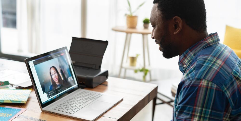 man looking at laptop with a woman on it